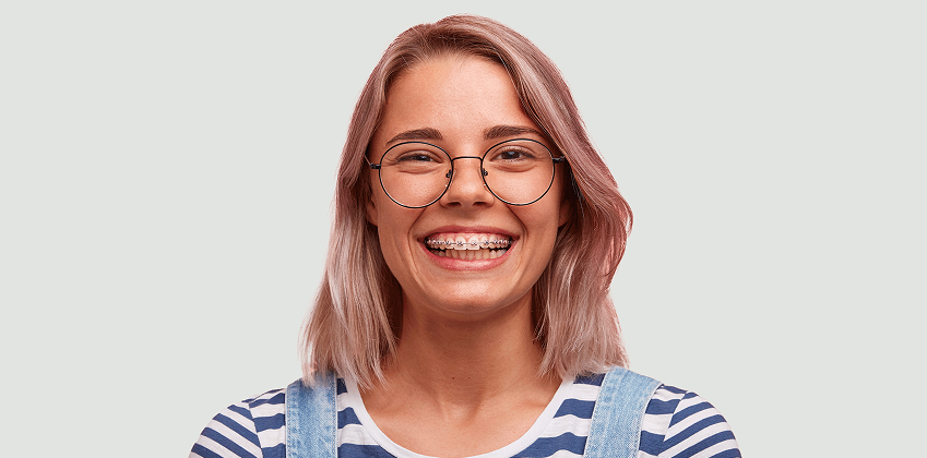 close up of a girl with braces in overhauls