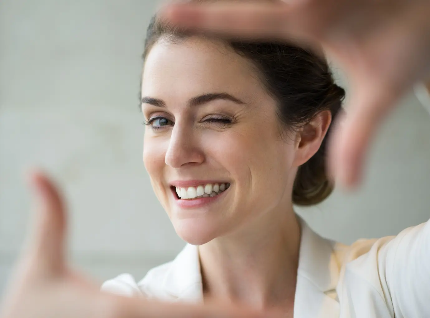 Woman holding hands up to frame her smile